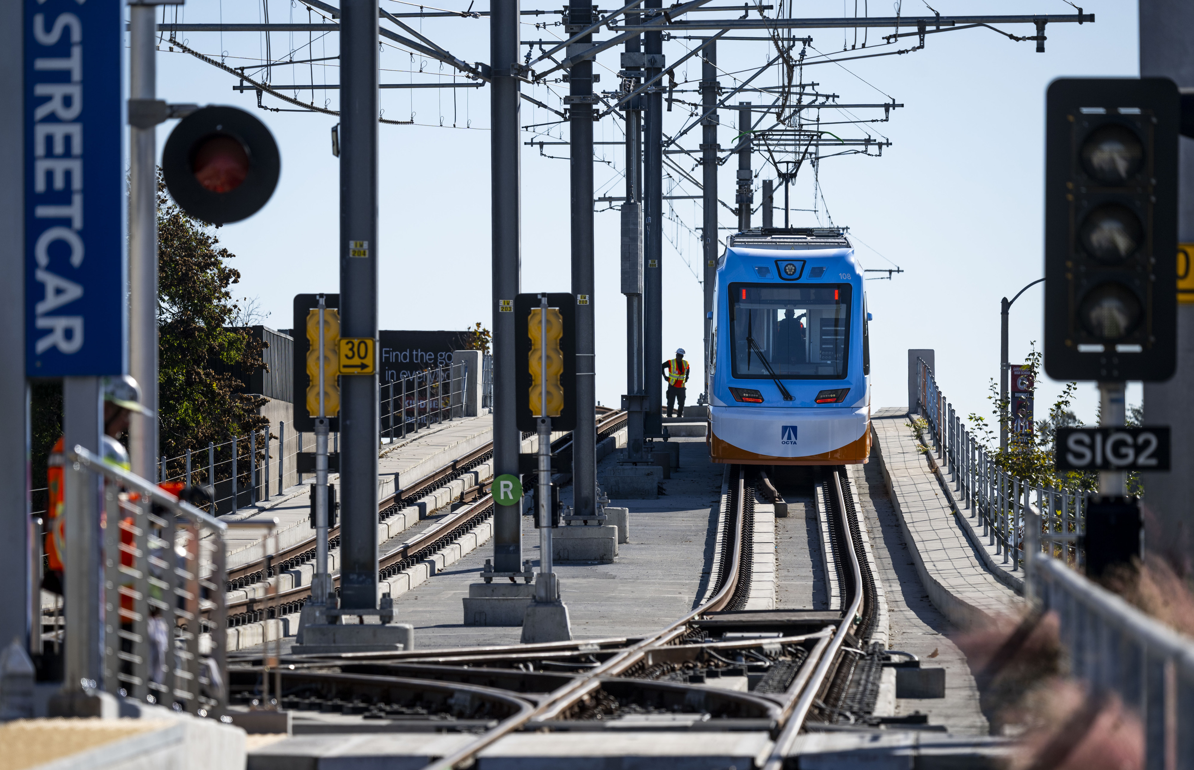 An OC Streetcar train pulls away from a stop at...