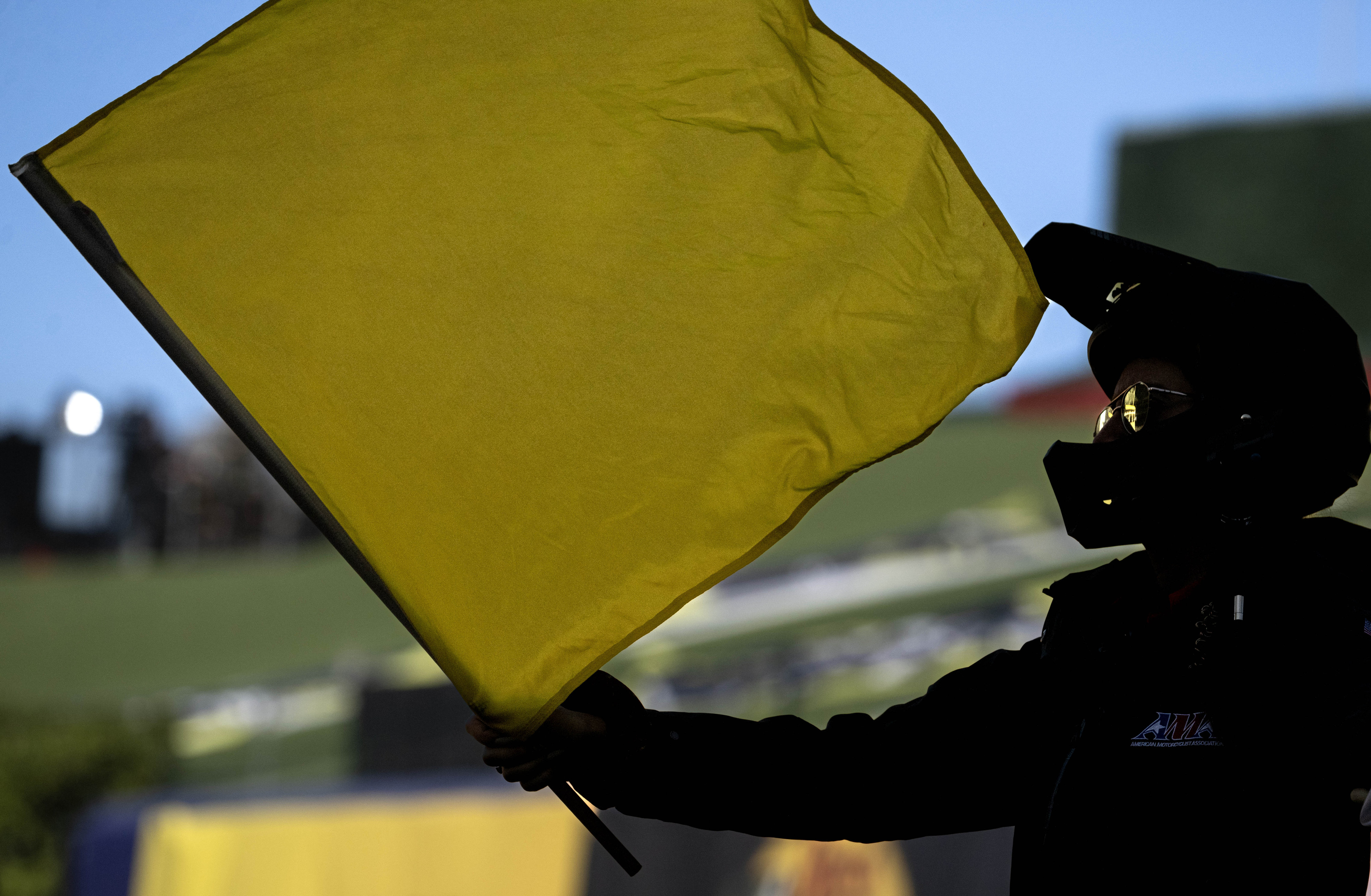 Racers in the Monster Energy AMA Supercross competition are flagged...