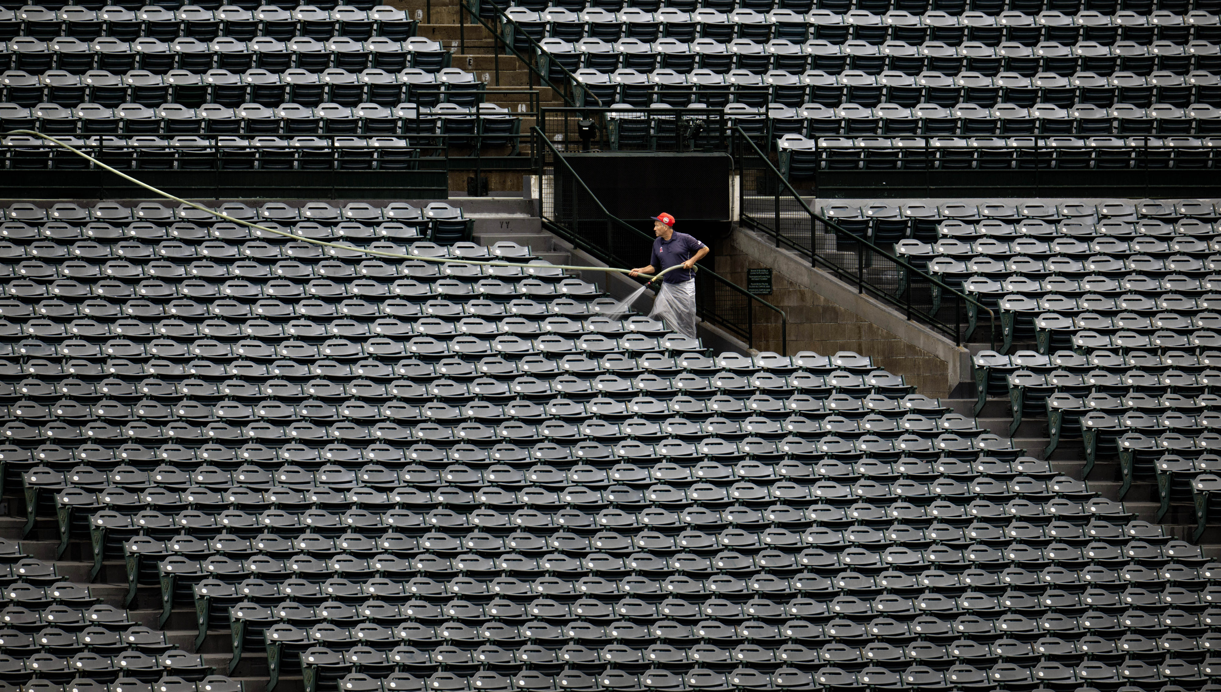 An Angel Stadium of Anaheim worker cleans the bleachers on...