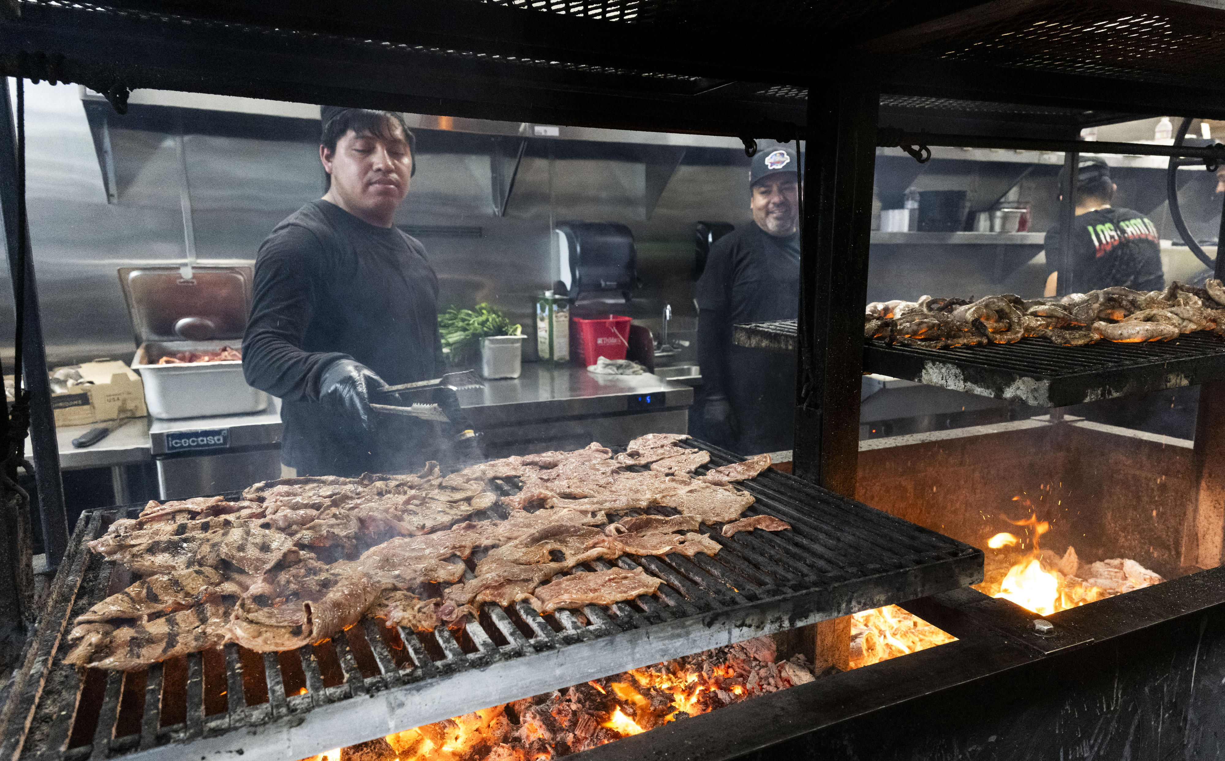 Meat is cooked over an open flame at Tacos Los...