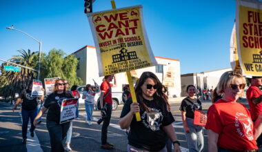 Teachers, parents, and community members cross the street to join the rally in front of Twin Rivers Unified School District on Tuesday, Oct. 21, 2025.