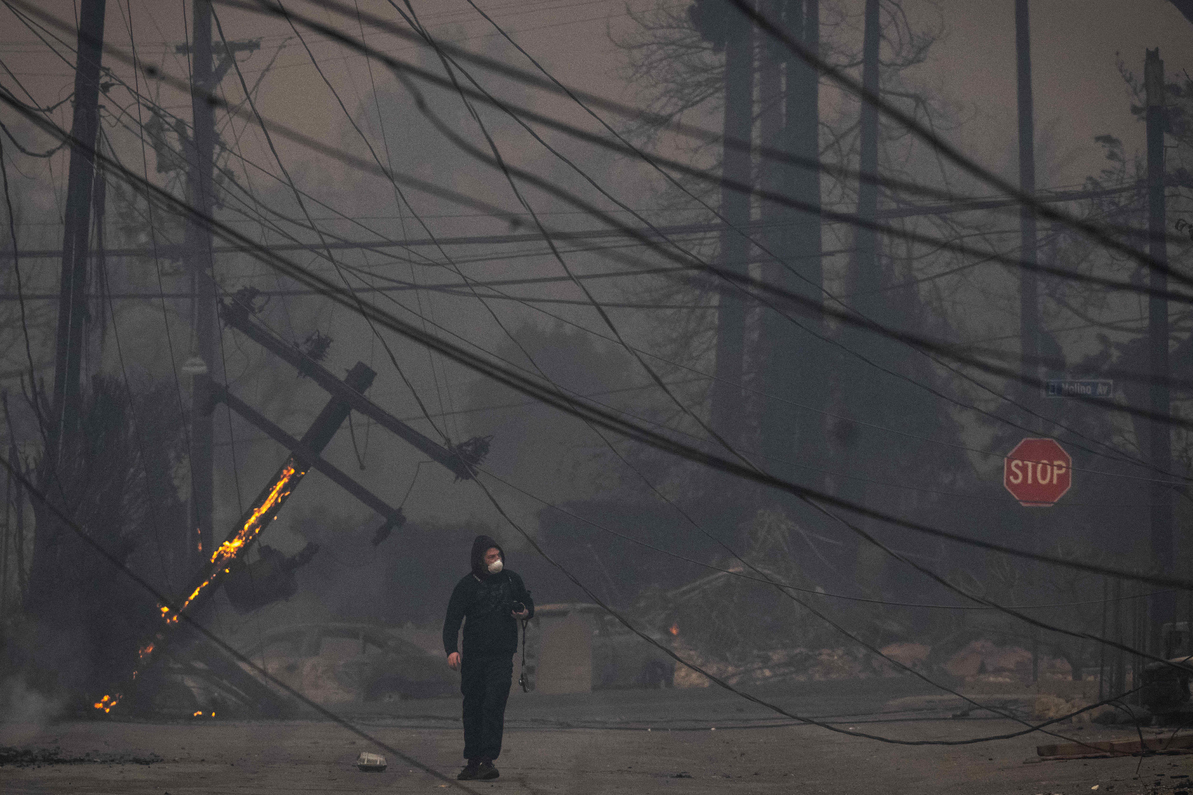 A man walks in Altadenaâs business district through downed power...