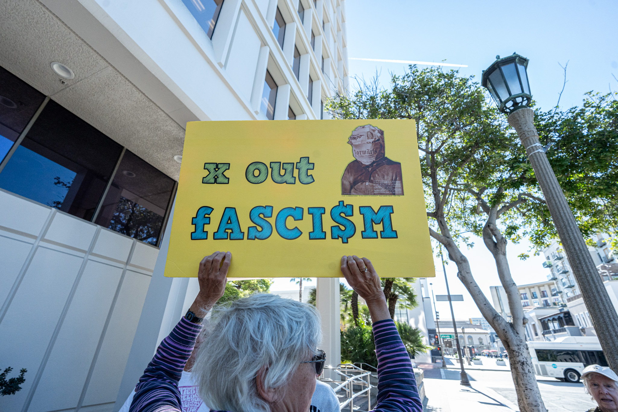 Debra Lemonds holding up a â X Out Fascismâ sign...