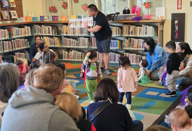 Librarian 1 Alex Areta reads the book, "The Very Hungry Caterpillar" to toddlers at the Poway Library on Thursday, Jan. 22. (Julie Gallant)