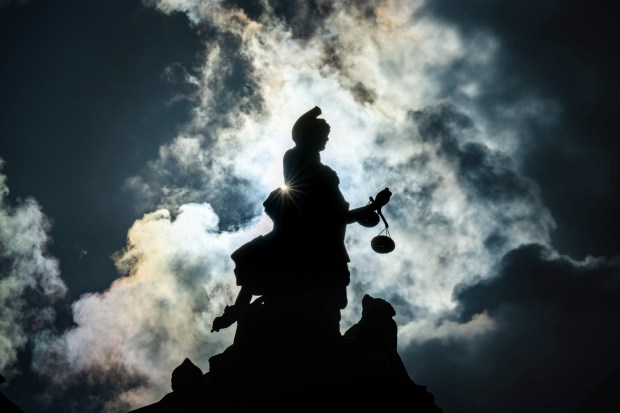 The Lady of Justice statue stands in silhouette against the clouds outside the Riverside Historic Courthouse in Riverside on Friday, Nov. 24, 2023. (Photo by Watchara Phomicinda, The Press-Enterprise/SCNG)