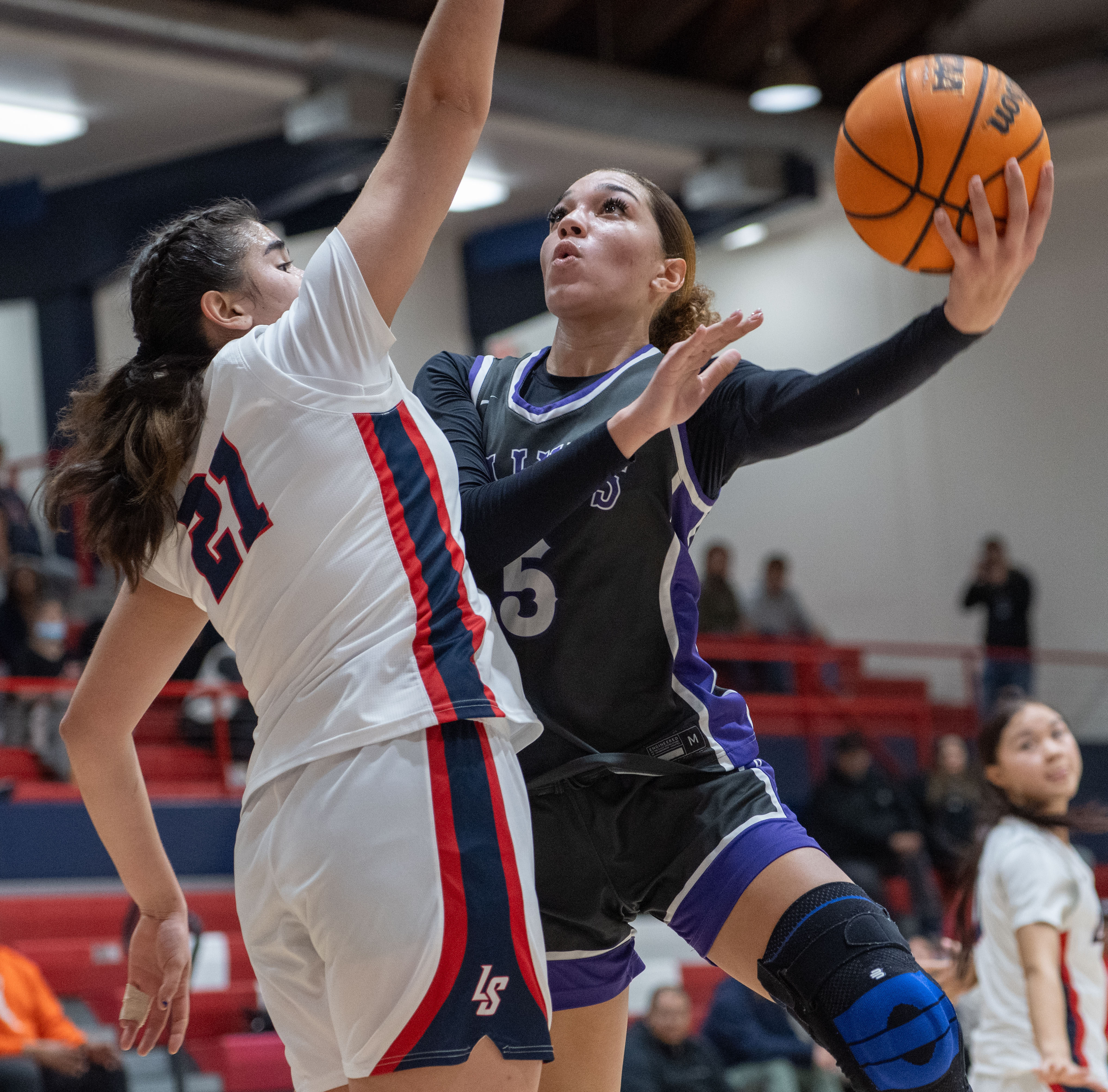 St. Anthony’s Dallyn Knox goes to the hoop under heavy...