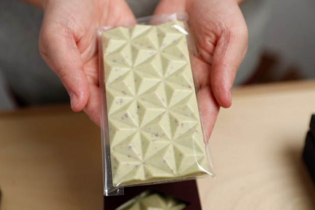 Michiko Marron-Kibbey, owner of Deux Cranes Confections, holds a "Pistachio Rose Chocolate," chocolate bar, in plastic wrap, at Deux Cranes Confections, at her store in Los Gatos, Calif. (Nhat V. Meyer/Bay Area News Group)