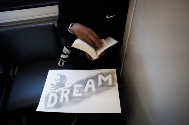 Christopher Dodd, 15, of Palo Alto, reads a book while riding the Caltrain NorcalMLK Celebration Train to San Francisco on Martin Luther King Jr. Day, Jan. 19, 2026. (Dai Sugano/Bay Area News Group)