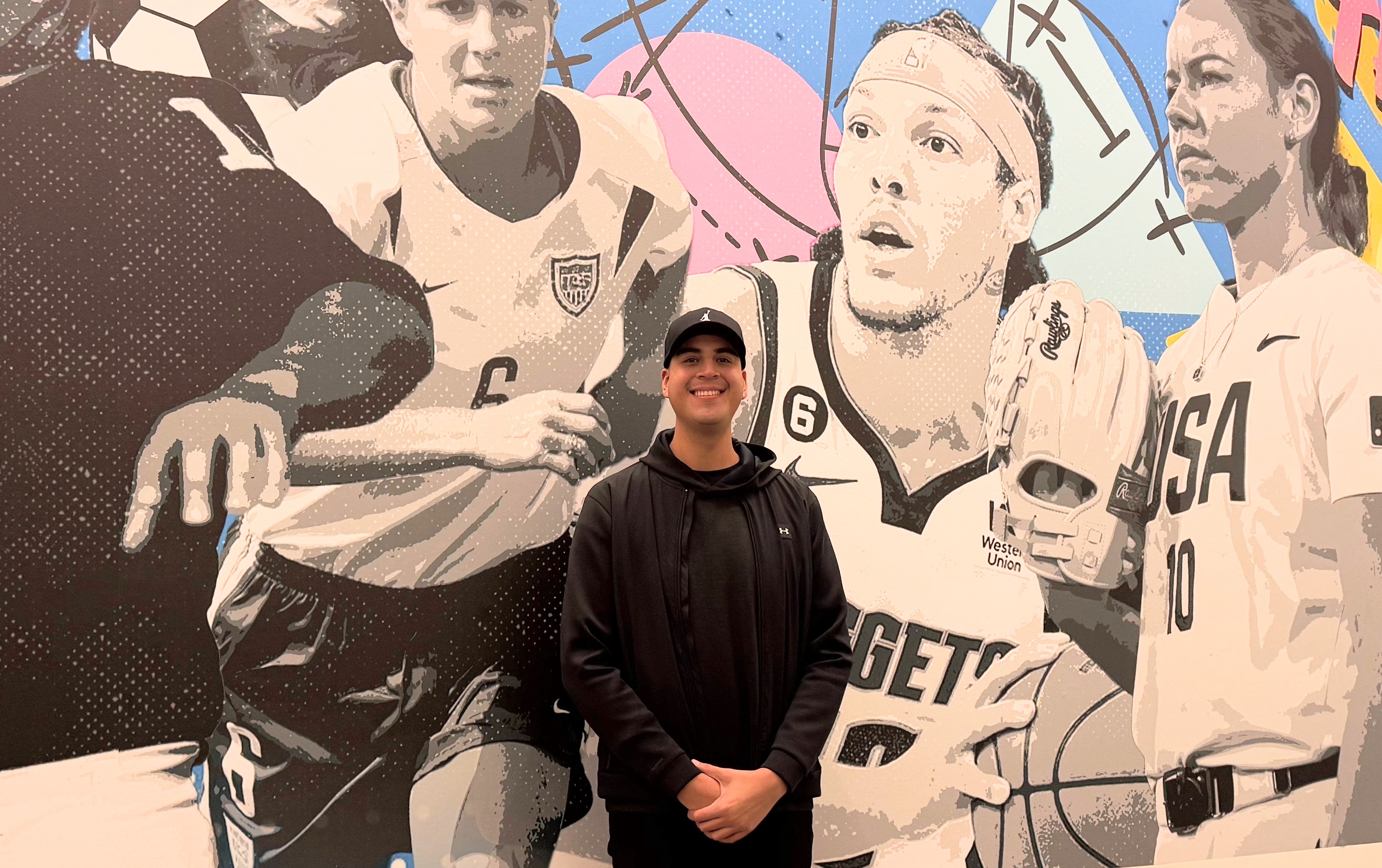 Artist Emilio Cortez stands with his mural, “San Jose Game...