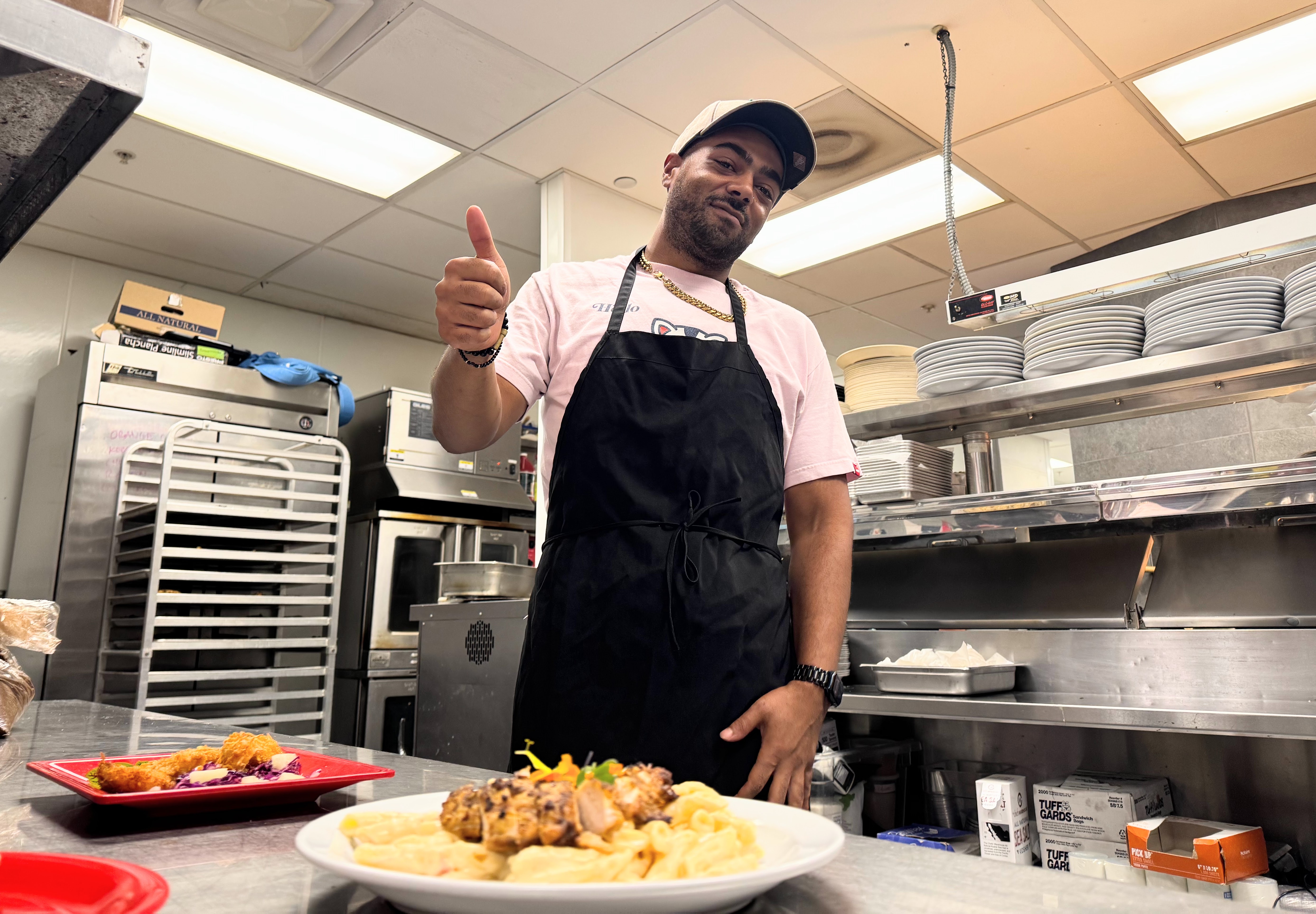 Chef Trevor Hansen poses with the sample dishes prepared for...