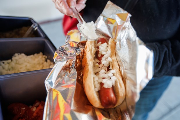 A customer loads condiments onto a hot dog at Howard Gibbins' hot dog stand Wednesday, Jan. 7, 2026, at the Santa Clara-Great America station in Santa Clara, Calif. (Dai Sugano/Bay Area News Group)