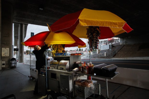 Hot dog vendor Howard Gibbins attaches a portable light to his stand at the Santa Clara-Great America station near Levi's Stadium in Santa Clara, Calif., Wednesday evening, Jan. 7, 2026. (Dai Sugano/Bay Area News Group)