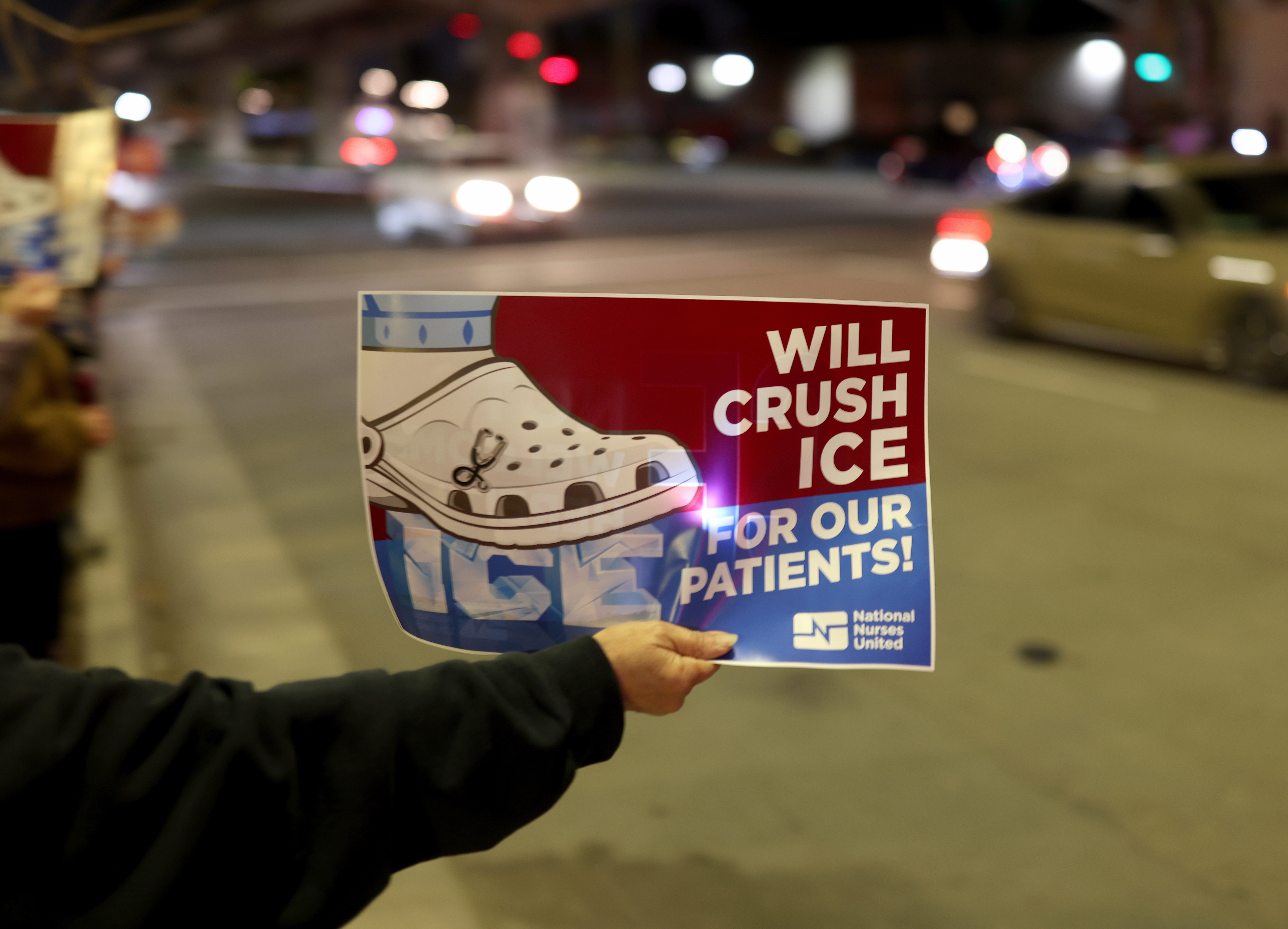 Healthcare workers and community members take part in a protest...