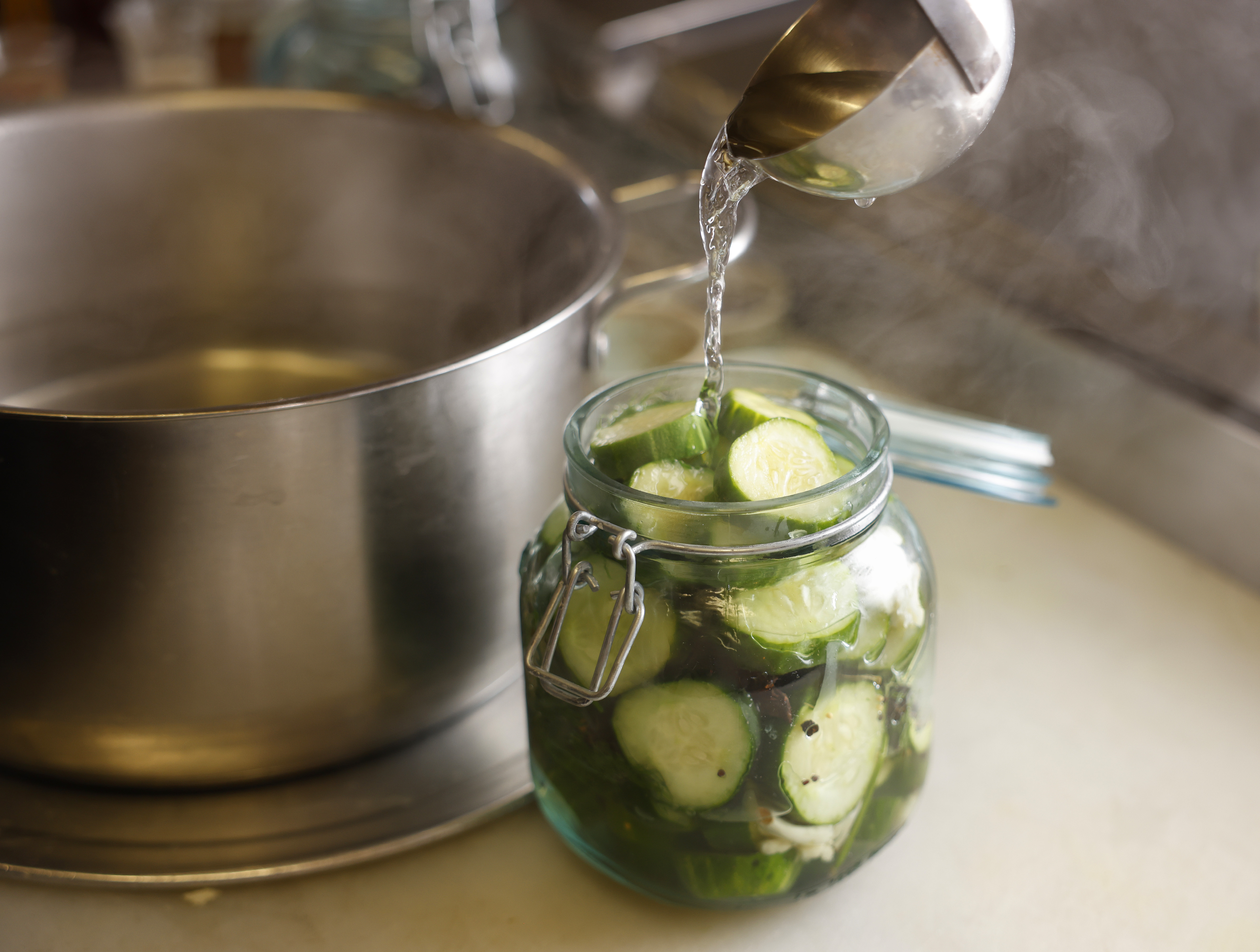 Brine is ladled over the pickles. (K.C. Alfred / The...