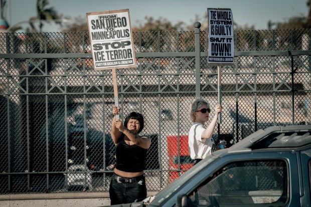 Demonstrators protest ICE on an overpass above the I-15 during a rally across from Teralta Park in City Heights on Friday, Jan. 30, 2026. (Photo by Sandy Huffaker for The San Diego Union-Tribune)