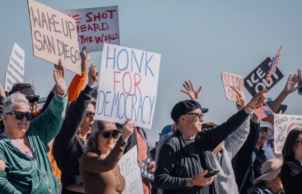 Protesters chant during a demonstration against ICE and the recent killing of Minnesota resident Renee Good on Saturday, January 10, 2026 at the corner of Crown Point Drive and Ingraham St. Pacific Beach. About 250 people joined the protest. (Sandy Huffaker / For The San Diego Union-Tribune)