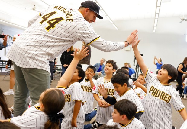 San Diego, CA - December 2: San Diego Padres pitcher Joe Musgrove high fives students at Rodriguez Elementary School after they were given new Padres-branded bikes and helmets at an assembly at the school on December 2, 2025 in San Diego, CA. The Padres surprised nearly 100 second and third grade students with the bikes in conjunction with Bikes for Kids Foundation and the Padres Foundation's Going to Bat for San Diego partnership with SDG&E. Members of the organization such as Chariman John Seidler, CEO Erik Greupner, Padres Foundation President Tom Seidler, alumnus Mark Loretta and broadcaster Mark Grant attended. (K.C. Alfred / The San Diego Union-Tribune)
