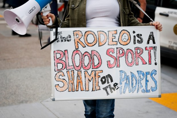 An animals rights protestor holds a sign outside Petco Park before the third annual San Diego Rodeo on Friday, Jan. 16, 2026 in San Diego, California. (Meg McLaughlin / The San Diego Union-Tribune)