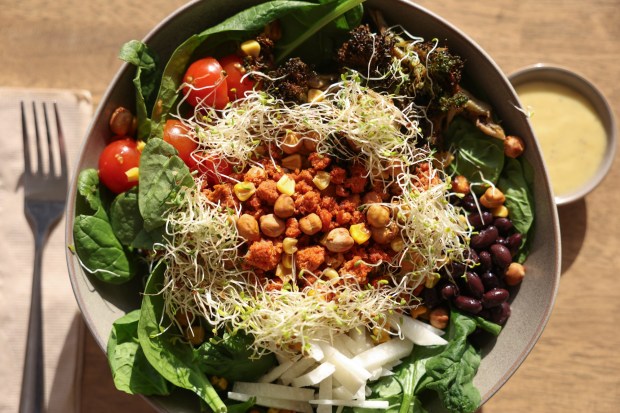 Spinach gets a boost from chickpeas, broccoli, corn, chorizo, black beans, cherry tomatoes, jicama and alfalfa sprouts. (Hayne Palmour IV / For The San Diego Union-Tribune)