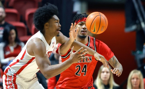 San Diego State guard Taj Degourville (24) tries to steal the ball from UNLV forward Jacob Bannarbie (10) during the first half of an NCAA college basketball game Saturday, Jan. 24, 2026, in Las Vegas. (Steve Marcus/Las Vegas Sun via AP)