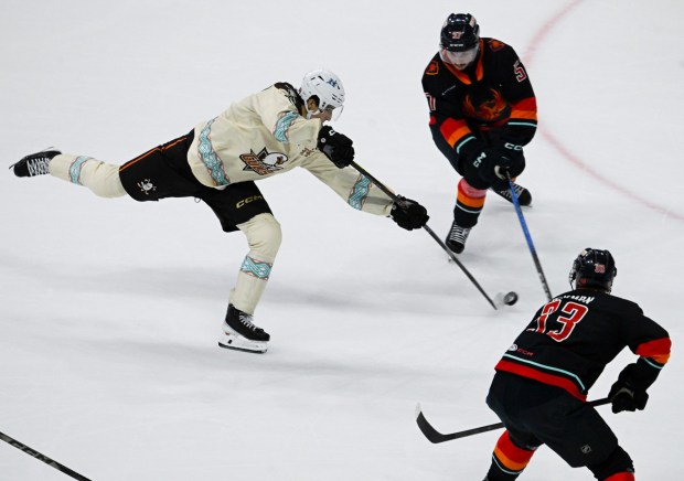 San Diego Gulls' Nikita Nesterenko (13) shoots past Coachella Valley Firebirds' Jagger Firkus (57) and Jani Nyman (33) during the second period Jan. 17, 2026 in San Diego, Calif. (Photo by Denis Poroy)