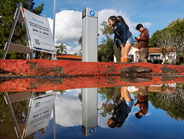 Crismar Chacin pays for parking at a kiosk in Balboa Park on the day it was implemented on Jan. 5, 2026, in San Diego. (K.C. Alfred / The San Diego Union-Tribune)