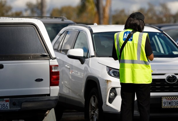An Ace parking attendant issues a warning ticket for a vehicle at the San Diego Zoo on Monday, Jan. 5, 2026, in San Diego. (K.C. Alfred / The San Diego Union-Tribune)