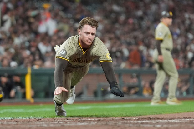 San Diego Padres' Bryce Johnson slides home to score against the San Francisco Giants during the seventh inning of a baseball game in San Francisco, Monday, Aug. 11, 2025. (AP Photo/Jeff Chiu)