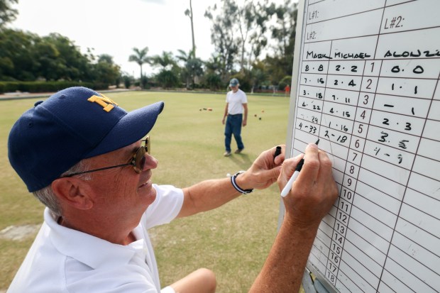SAN DIEGO, CA - January 03, 2026: San Diego Lawn Bowling Club member Mark Keams writes down the scores of the singles game he's competing in at Balboa Park in San Diego on Saturday, January 03, 2026. (Hayne Palmour IV / For The San Diego Union-Tribune)