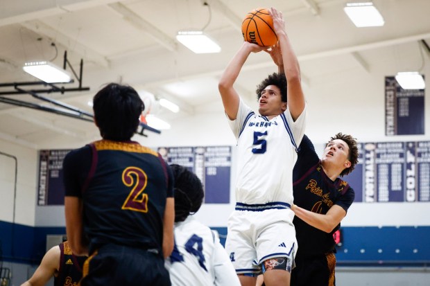 Madison's Eli Stevens #5 goes up for a shot against Point Loma's Myles Caldwell #0 during their game at Madison High School on Tuesday, Jan. 13, 2026 in San Diego, California. (Meg McLaughlin / The San Diego Union-Tribune)