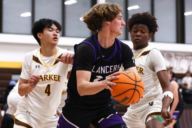 Carlsbad High's Jake Hall looks to pass against Francis Parker's Tavid Johnson (right) in a game last January. (Meg McLaughlin / The San Diego Union-Tribune)