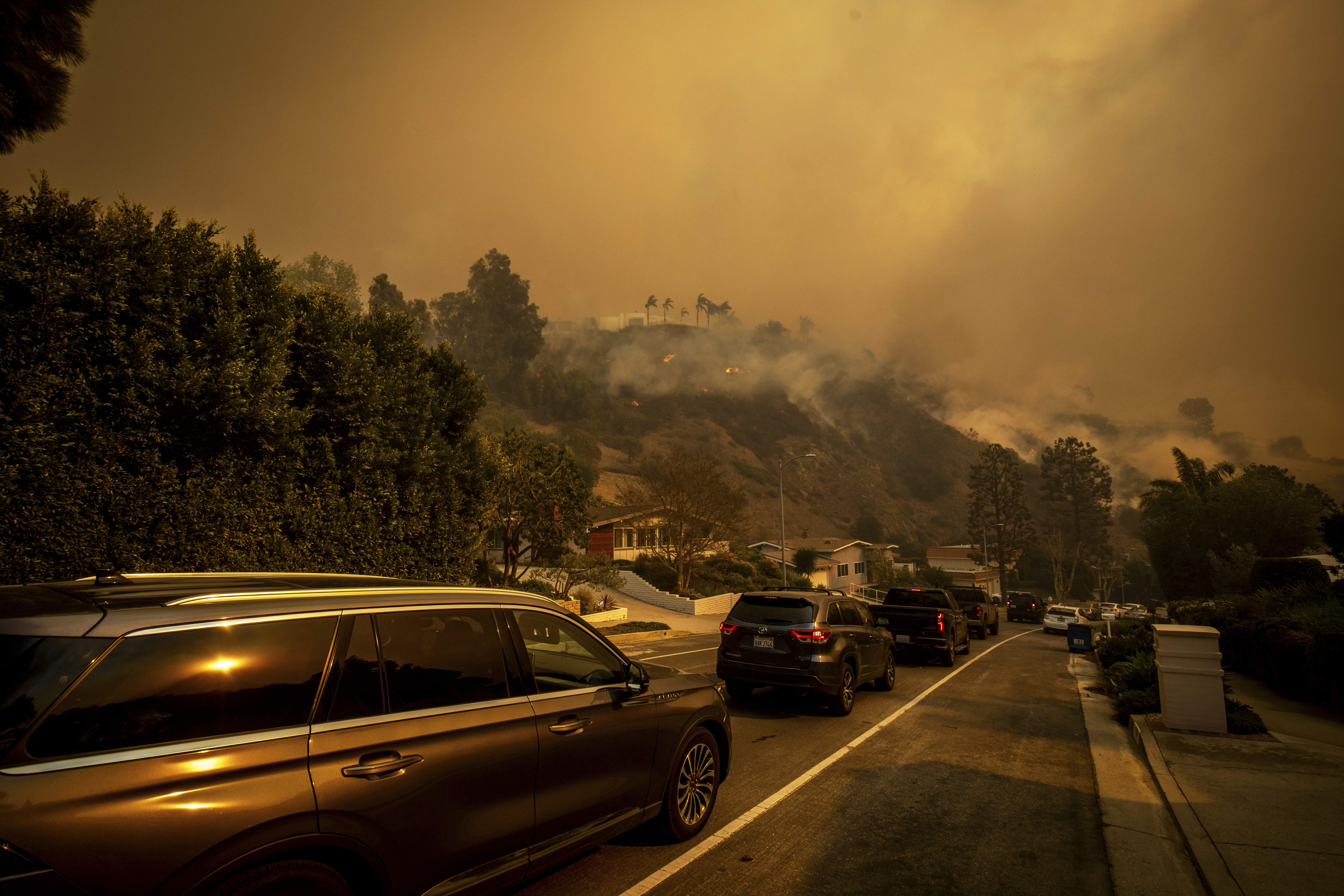 A line of vehicles crowd the road as residents flee...