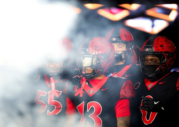 Malachi Finau #55, Nathan Acevedo #13, Bryce Phillips #0 of San Diego State look on before their game against San Jose State at Snapdragon Stadium on Saturday, Nov. 22, 2025 in San Diego, California. (Meg McLaughlin / The San Diego Union-Tribune)