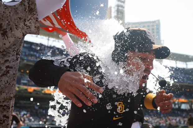 San Diego Padres' Jose Iglesias is doused by Jackson Merrill and Tyler Wade after a walk-off fielder's choice against the Kansas City Royals at Petco Park on Sunday, June 22, 2025 in San Diego, CA. (Meg McLaughlin / The San Diego Union-Tribune)