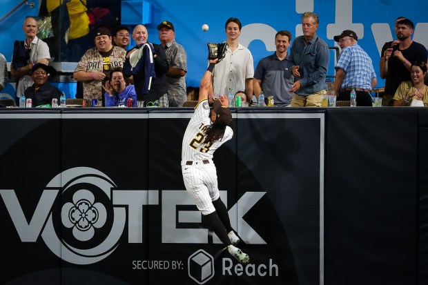 Fernando Tatis Jr. #23 of the San Diego Padres leaps to catch a fly ball hit by Tyler Stephenson #37 of the Cincinnati Reds during the fourth inning against the Cincinnati Reds at Petco Park on Tuesday, Sept. 9, 2025 in San Diego, California. (Meg McLaughlin / The San Diego Union-Tribune)