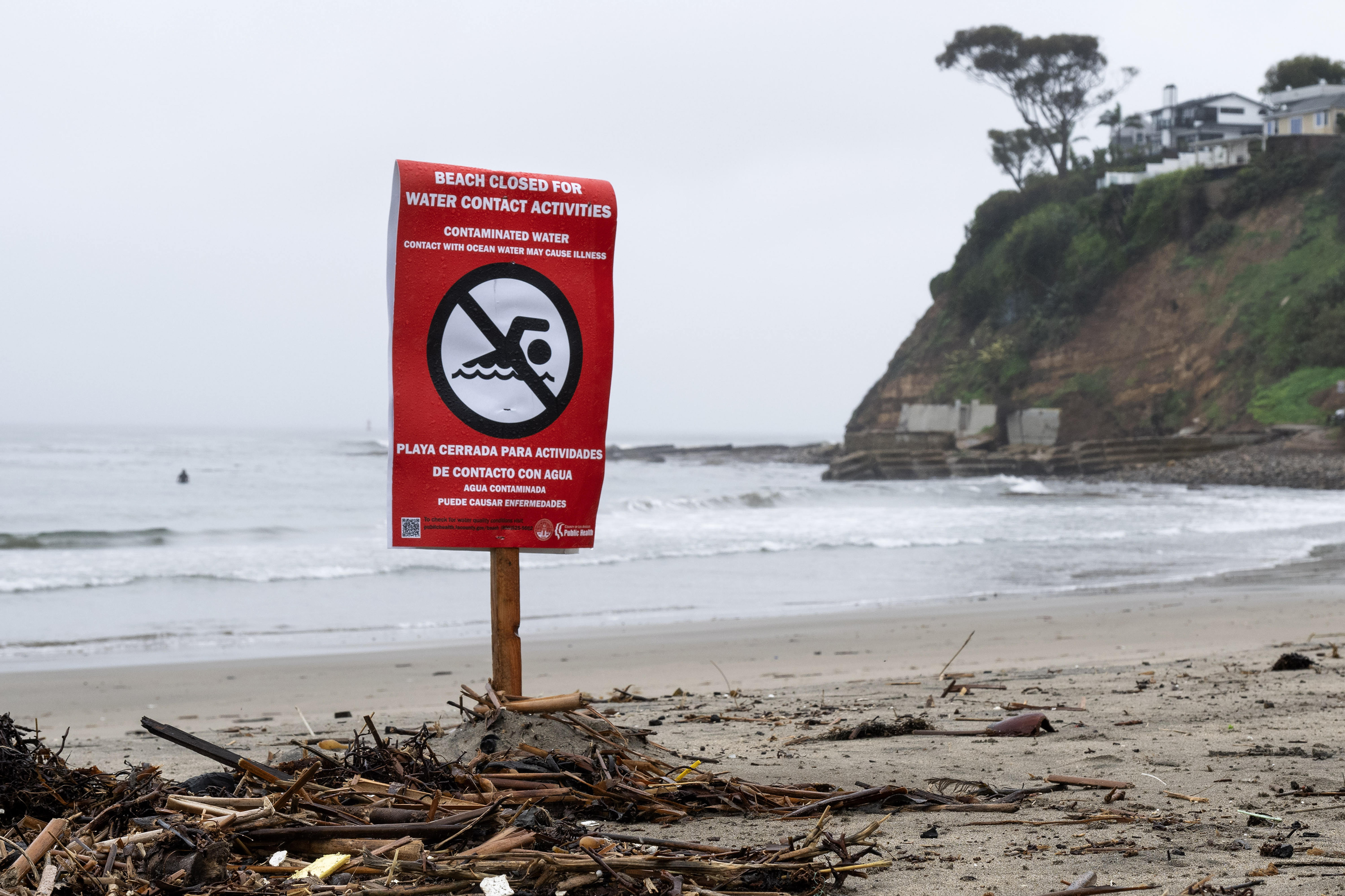 Beach closure signs are posted on the south side of...