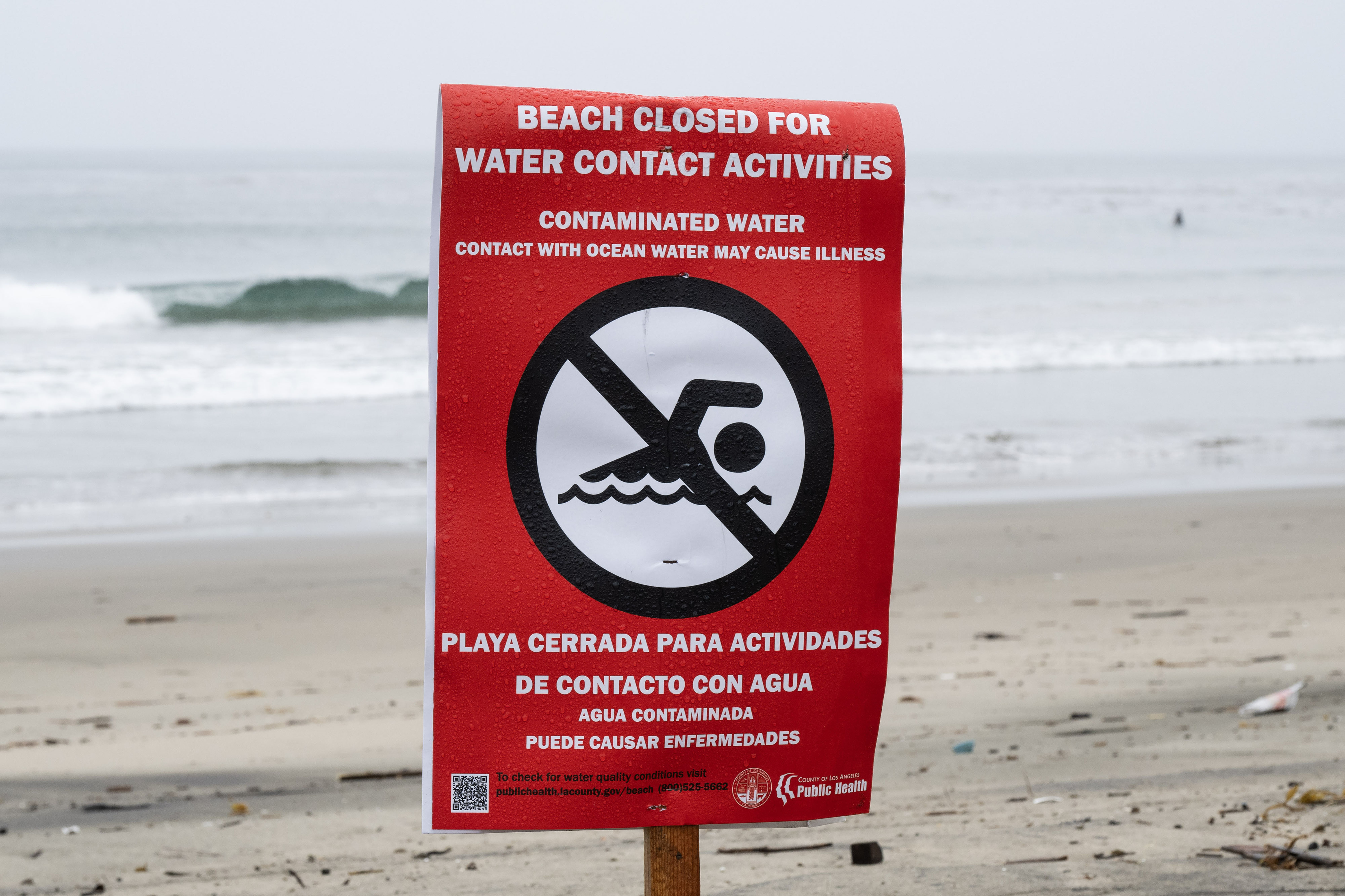 Beach closure signs are posted on the south outer side...