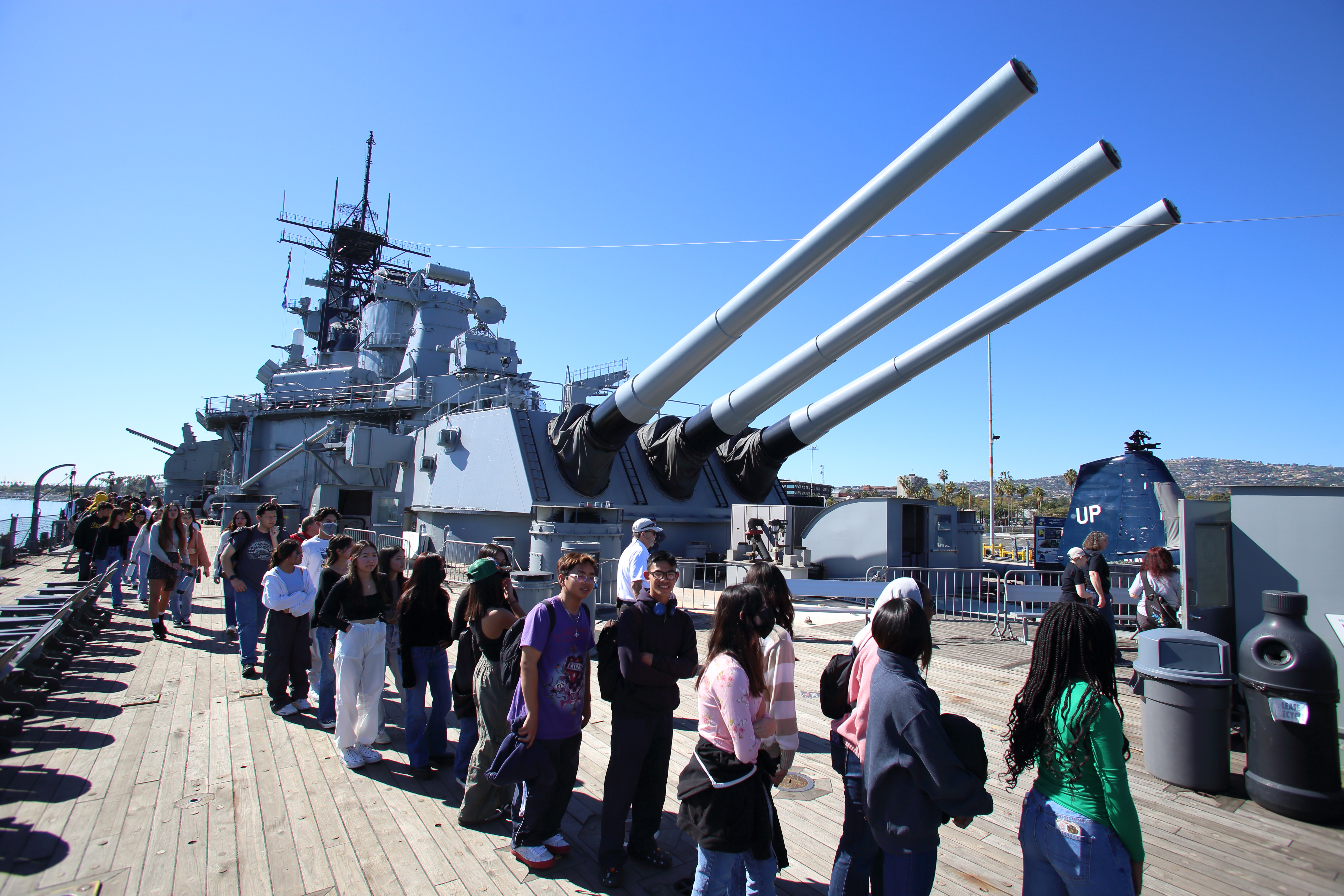 Hundreds of high school students stream past the guns of...