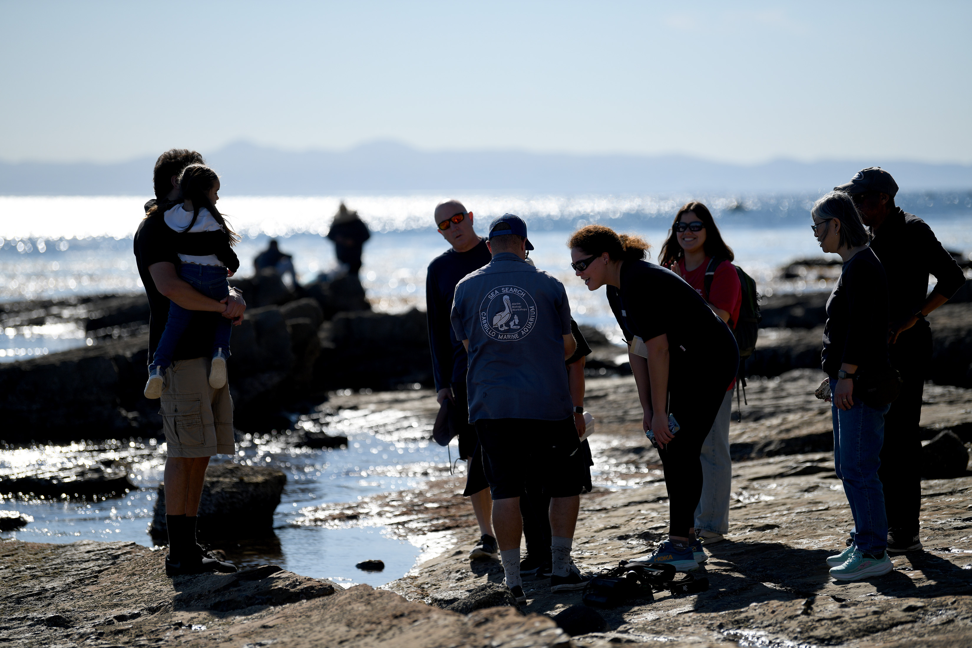Aquarium educators guide participants on a Cabrillo Beach walk through...