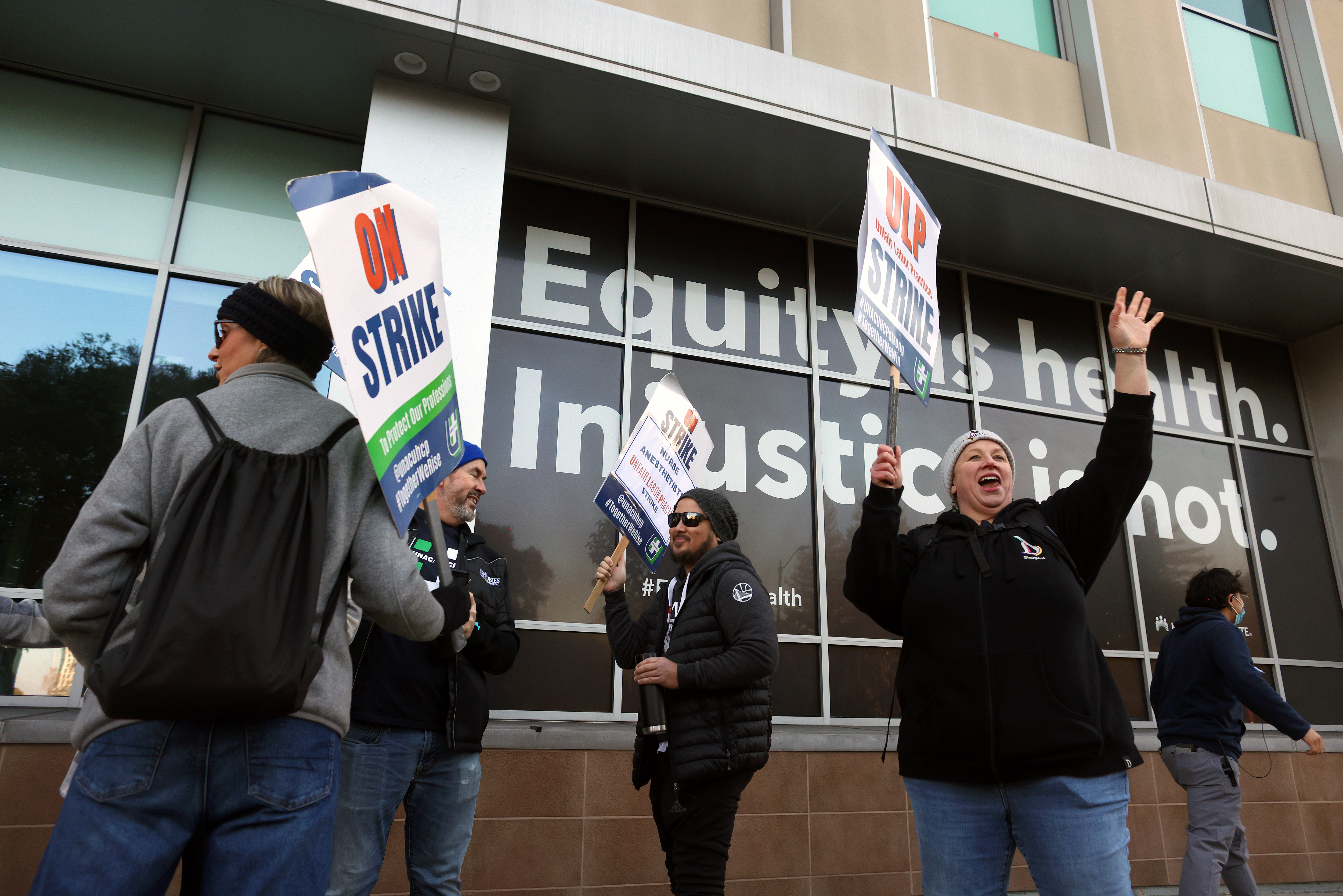 Medical workers and their supporters walk a picket line outside...