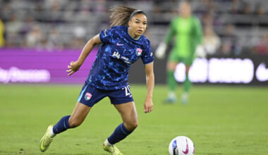 A soccer player in a blue uniform controls the ball on the field