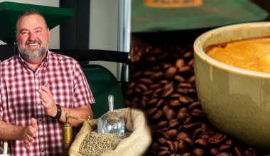 a man grinding coffee beans next to a large cup of coffee
