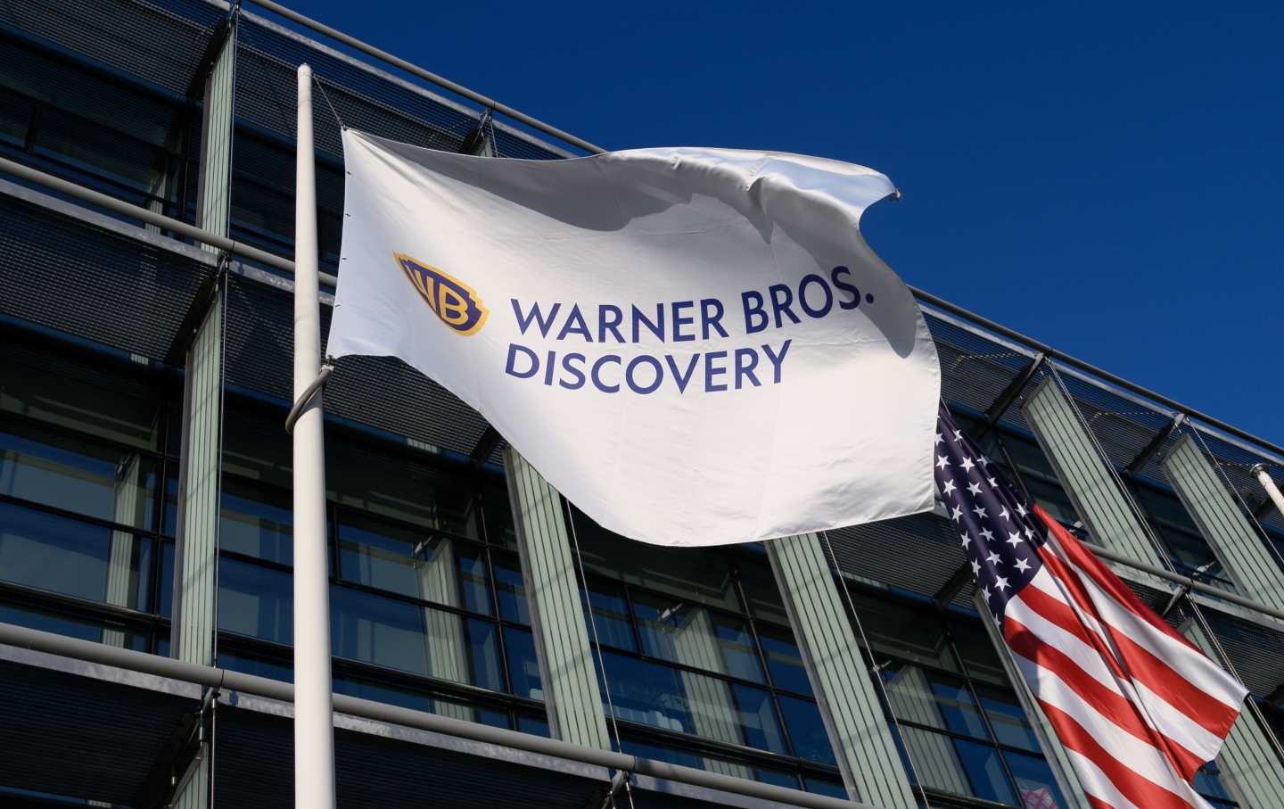 The Warner Bros. Discovery flag alongside the American one, outside Warsaw’s TVN broadcasting studio