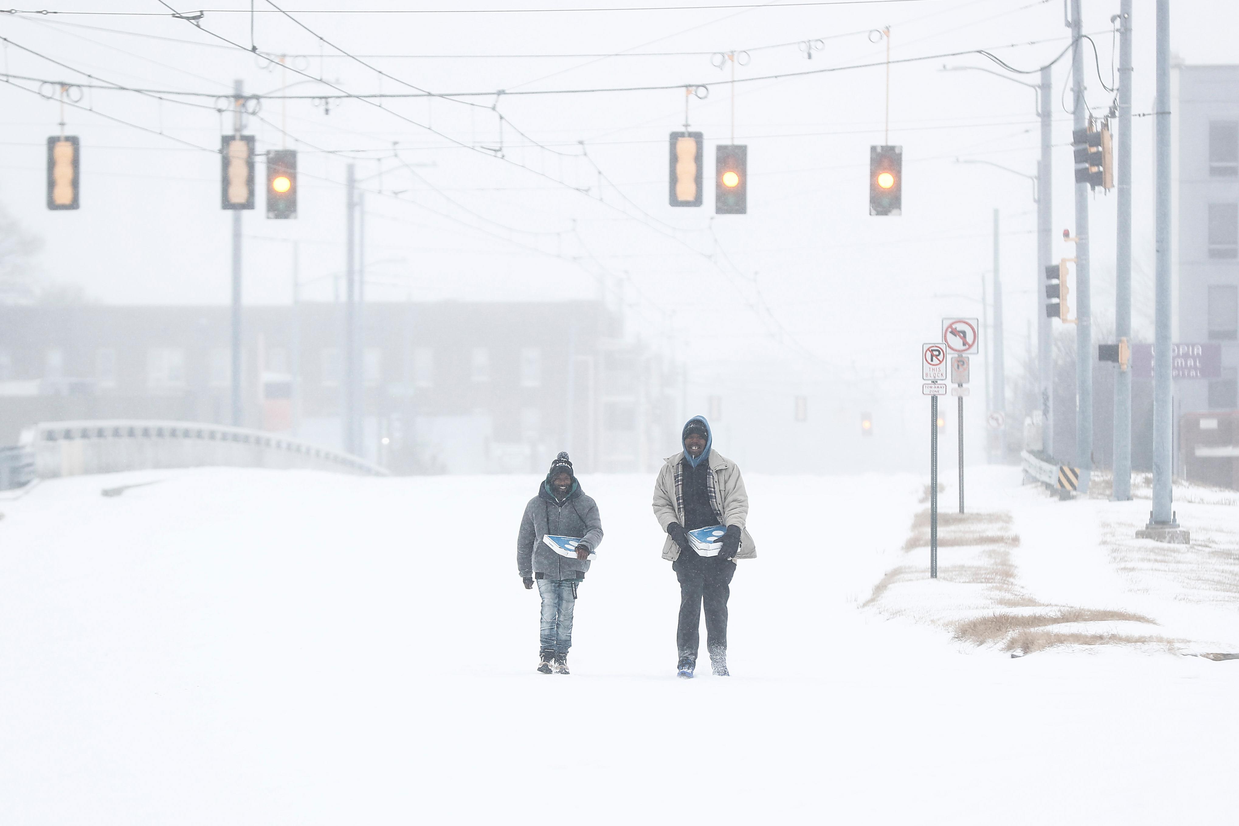Jimmy Jordan, left, and Cordarol Dale walk through snow in...