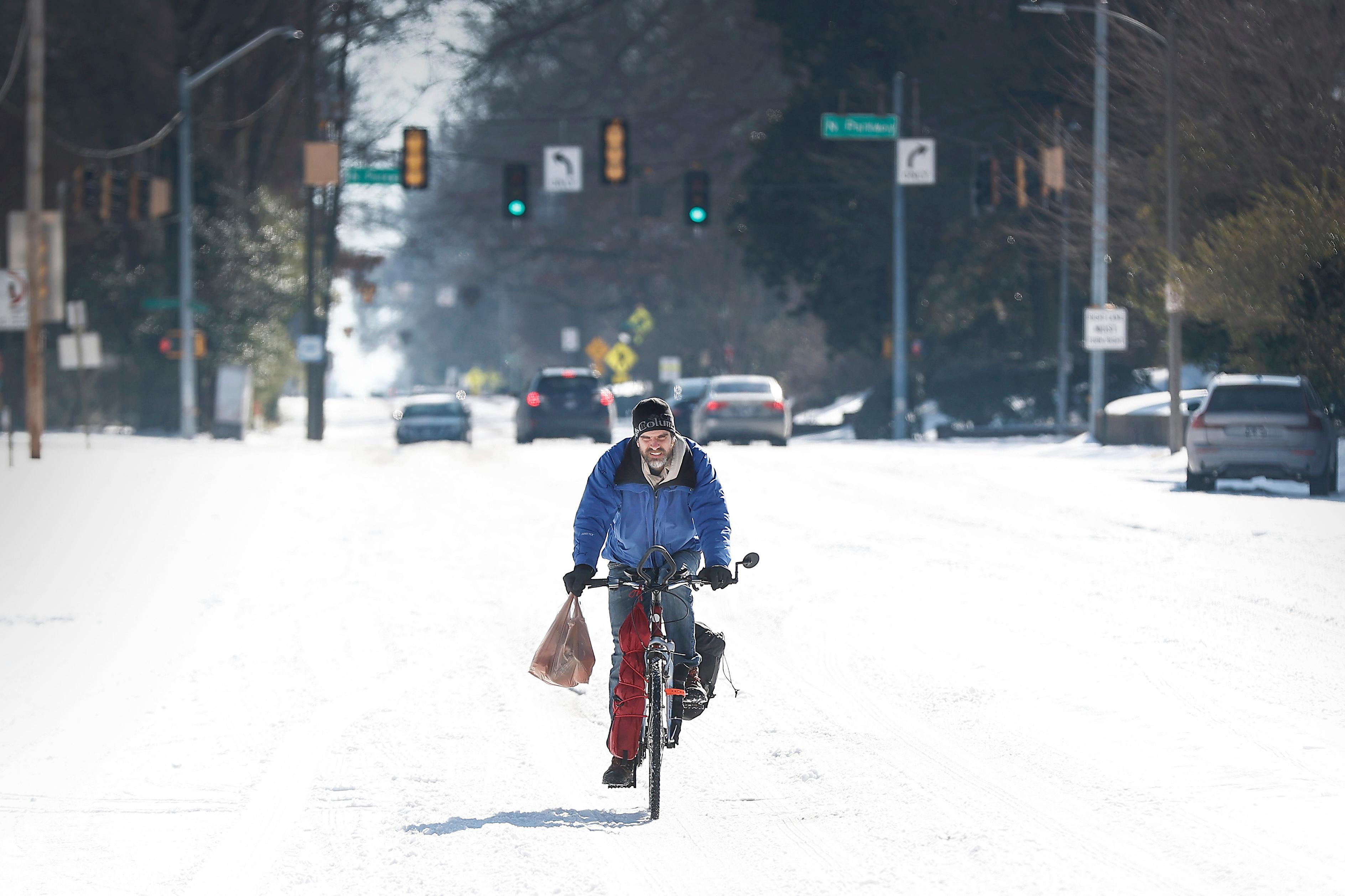 Jean Christophe rides his bike home from Kroger on snow...
