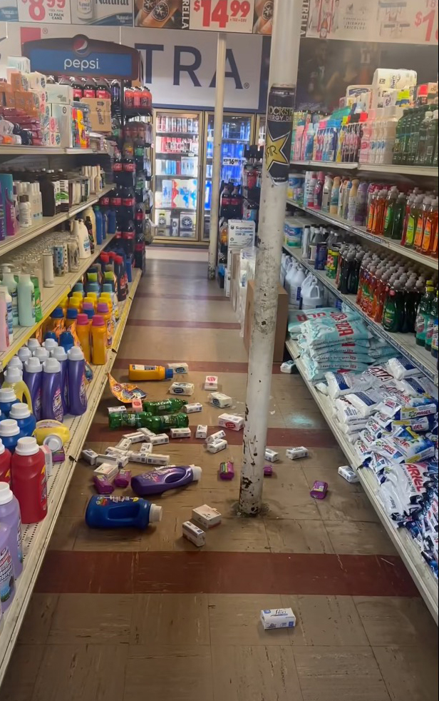 Store aisle with products fallen from shelves onto the floor after an earthquake.