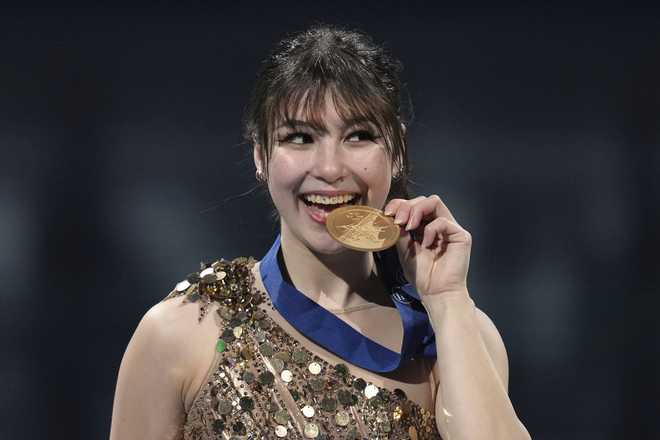 gold medalist alysa liu, of the united states bites her medal during a ceremony for the women's free skating program at the figure skating world championships, friday, march 28, 2025, in boston. (ap photo/charles krupa)