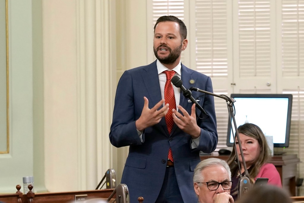 Assemblyman Matt Haney speaking at a podium in a legislative chamber.
