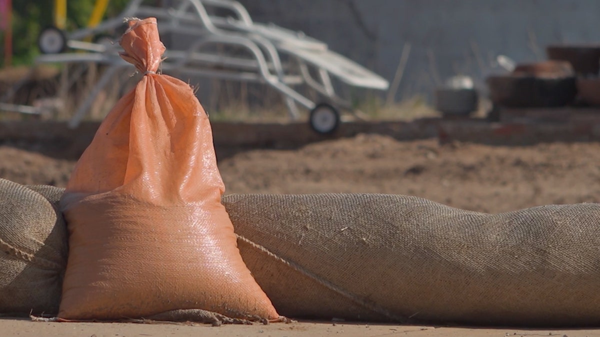 A sandbag sits at a construction site where a home is being rebuilt after a wildfire.