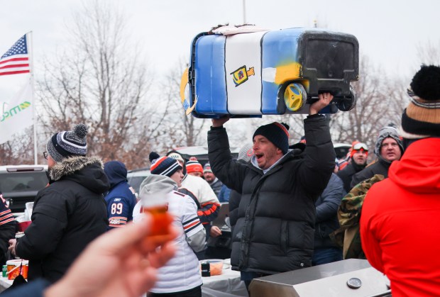 A fan carries a Rams colored trashcan outside as fans tailgate outside of Soldier Field before the Chicago Bears play the Los Angeles Rams in the NFC divisional playoff game on Jan. 18, 2026. (Eileen T. Meslar/Chicago Tribune)